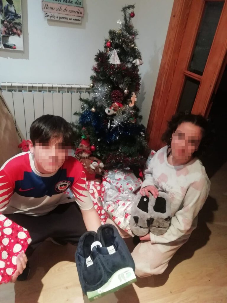 Menores cogiendo los regalos que Papá Noel les ha dejado