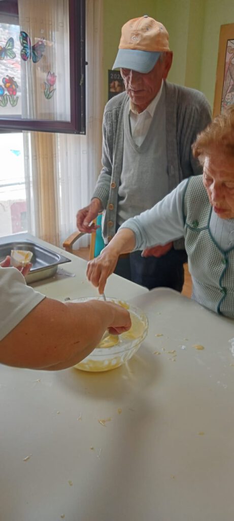 2 de nuestros mayores haciendo magdalenas durante uno de los talleres de cocina
